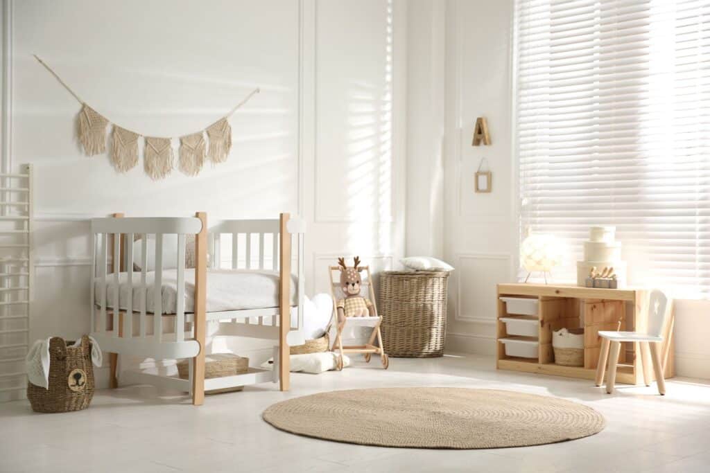 minimalistisch eingerichtetes babyzimmer mit beistellbett in weiss und naturtoenen