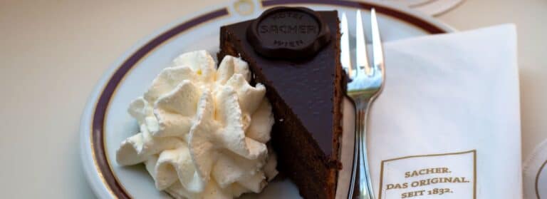 sachertorte mit schlagobers auf porzellanteller in wien